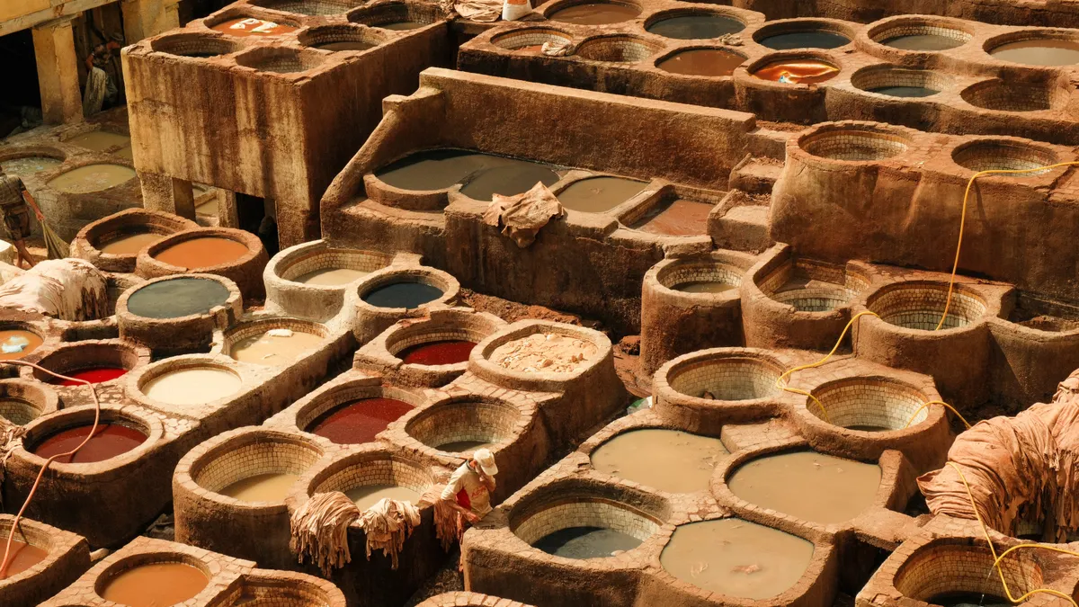 View of the traditional tannery filled with colorful dye vats in Fes, Morocco.
